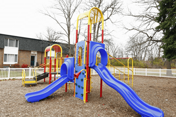 a playground with a blue and yellow swing set